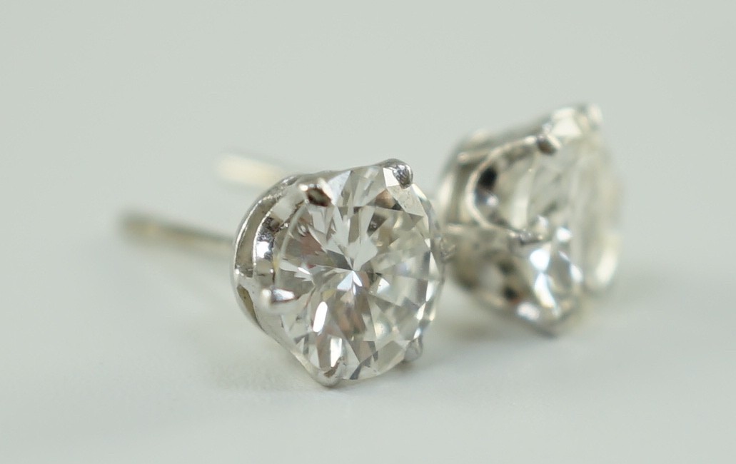 A pair of white gold and solitaire diamond set ear studs